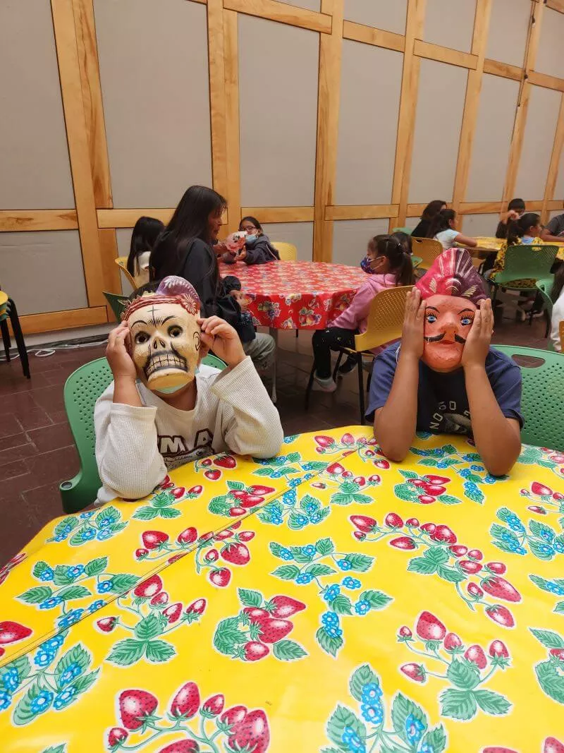 Students wearing masks and sitting at table at Museum of International Folk Art.