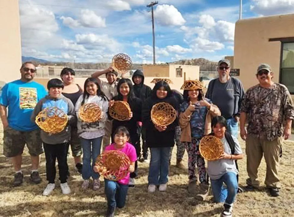 Students posing with the baskets they weave.