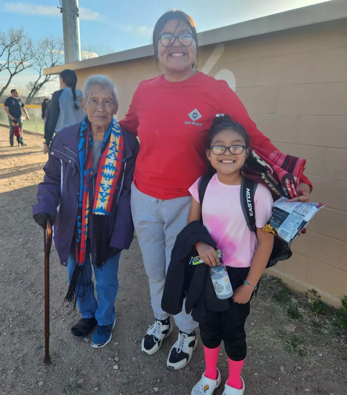 Two young ladies standing outside with their great grandmother