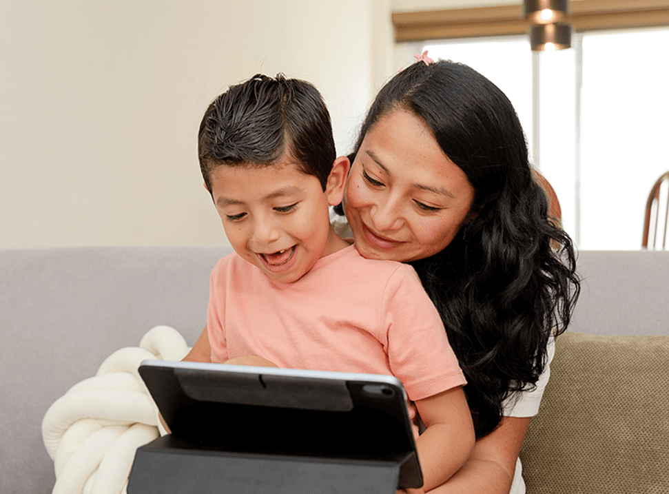 Mother reading to her son while he sits on her lap.
