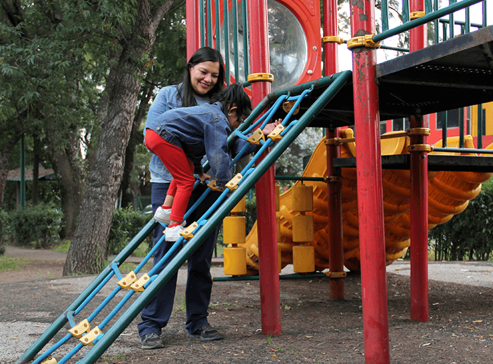 Mother playing with daughter on the playground.