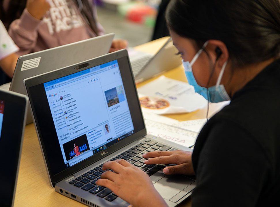Young student doing her lesson on a computer in class. 